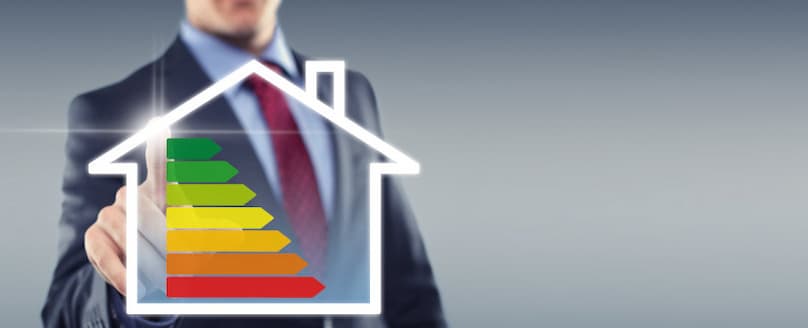 Energiespartipps - Mit TEGA richtig heizen Mann-im-Anzug-zeigt-auf-den-gruenen-Balken-einer-Energie-Anzeige-fuer-das-Haus-von-gruen-bis-rot